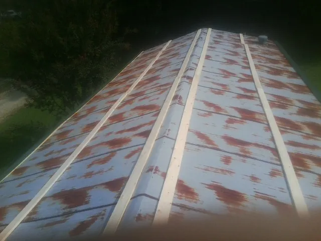 Rusted metal roof panels with new wood purlins before replacement — Storm Damage Roof Repair in Wana by Roofing Brothers